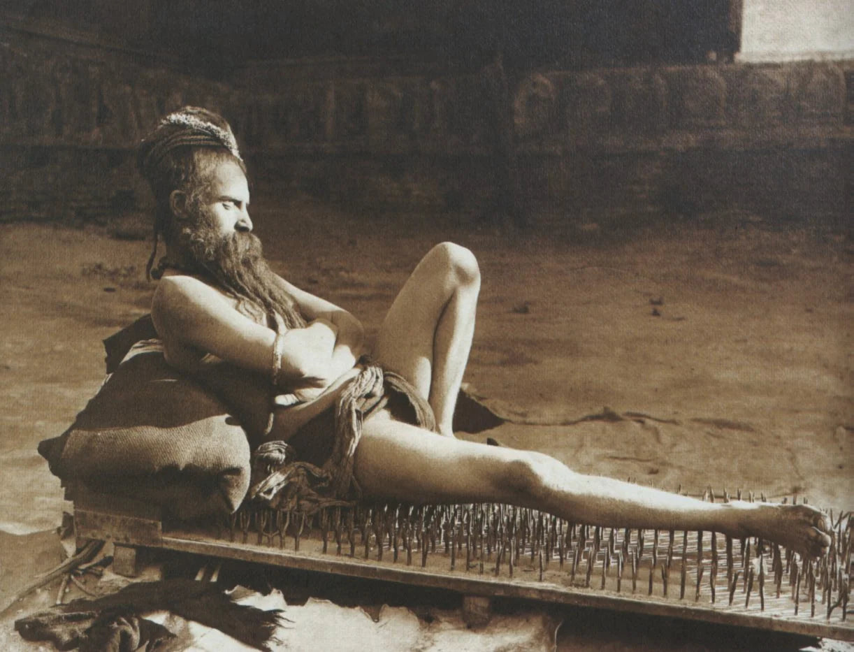 Historic photograph of a man reclining on a bed of nails